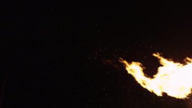 Parlak alevlerin büyüleyici ve büyüleyici görüntüsü ve uçan kıvılcımlar karanlık çevreyi aydınlatıyor.