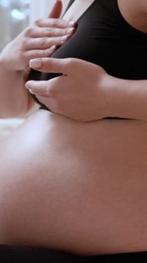 Üst masajdaki hamile kadın göğsünde rahatsızlık hissediyor. Gelecekteki özenli anne vücudundaki değişiklikleri gözlemler.