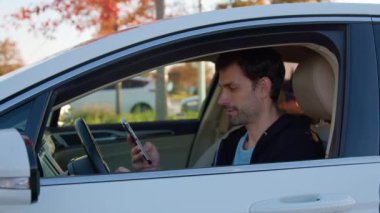 Mutlu adam ekranda otomobil paylaşım uygulamasını gösteriyor. Sakallı şoför araç kiralamak için uygun servisi öneriyor