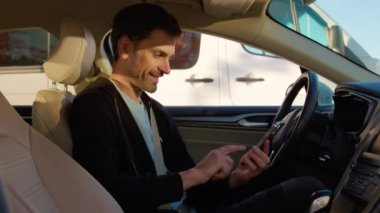 Müşteri, araba paylaşım uygulamasında geri bildirim bırakır. Otomatik olarak gülümseyen erkek sürücü, çevrimiçi hizmetten memnun olduğunu belirten bir telefon ekranı gösteriyor