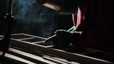 Demirci merdiven iskeletini kaynak meşalesiyle dikkatlice bağlar. İnsan güvenlik ve istikrar için metal iskeletinin dayanıklı yapısını sağlar