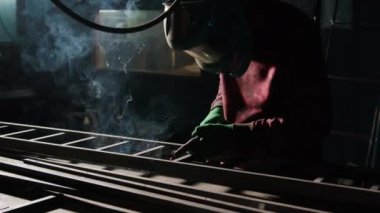 Demirci metal merdiven parçalarını kaynak makinesiyle birleştiriyor. Erkek metal işçisi, çerçeve bağlantılarını dikkatlice kaynak yaparak kesin sonuçlar sağlar