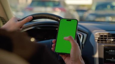 Adam trafikte araba paylaşım uygulaması kullanarak akıllı telefonu tutuyor. Erkek sürücü, araç sahipleri için para kazanmanın yollarını inceliyor.