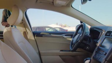 Adam akıllı telefondaki mobil uygulamayı kullanarak araba paylaşım aracının kilidini açıyor. Erkek sürücü kiralık aracı cep telefonundaki sanal anahtarla açıyor. Kabinden görüntüle