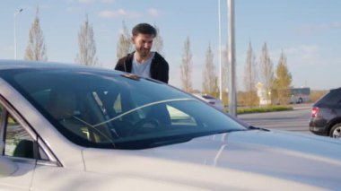 Gülümseyen adam yolculuğuna başlamak için araba paylaşım aracına biner. Erkek sürücü, kiralık arabayla gideceği yere giderken mutluluğunu ifade ediyor
