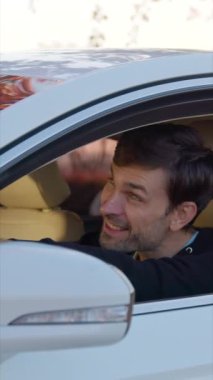 Araba paylaşımı müşterisi arabada otururken dikiz aynasına bakar. Adam dinlenme sahnesinde kenti ön camdan ve yan pencereden izliyor.