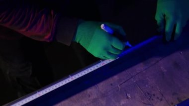 Eldivenleri olan bir tamirci demirden faydalı bir ev eşyası yapar. Bir adam demir parçasındaki mezurayla yan ölçüler alıyor. Yukarıdan Görüntü ile hobi çalışması