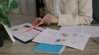 İş kârını arttırma stratejileri. Birkaç şirketin belirli bir süre boyunca gerçekleştirdiği istatistikleri analiz eden bir kadının yakın plan görüntüsü..