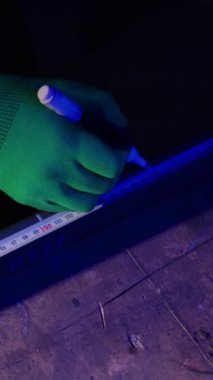 Demirci eldiveni, fabrikanın yakın çekiminde metal levha üzerindeki mesafeleri gösteriyor. Metal işçisi kesim için çelik malzemesi hazırlıyor.