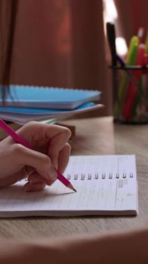 Bayan öğrenci okuma odasında otururken ders kitabından önemli notlar yazar. Solak mezun üniversitede okumak için en sessiz yeri kullanıyor.