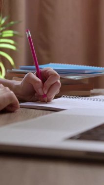 Genç bir kadın dizüstü bilgisayardaki metni analiz ederken akademik özetler yazıyor. Bayan öğrenci kağıt deftere yazı yazıyor. Okuma odasında online makaleyi gözden geçiriyor.
