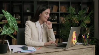 Ofiste e-postaları kontrol eden neşeli bir çalışan. Gülümseyen yönetici internette başarı haberlerini okuyor. Ofiste çalışan heyecanlı gülümseyen kadın, yeni iş tanıtımından memnun..