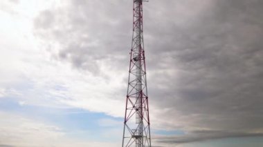 Uzun telekomünikasyon kulesi radyo dalgaları gönderiyor. İnşaat, sabit sistem sağlayan cep telefonu ve televizyon sinyalleri ile etkileşim halinde
