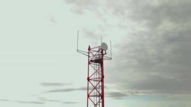 Telekomünikasyon kulesi bulutlu gökyüzüne karşı anten kullanarak sinyaller alıyor. Özel ekipman, uçbirim cihazları için görünmez radyo dalgaları yayar