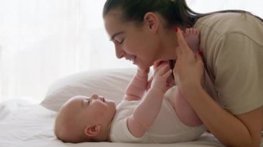 Güneşli bir sabah genç annesi yeni doğmuş bebeğini seviyor. Bir bebeğin yan görüntüsü yere yatar ve anne onun elleri ve ayaklarıyla ötüp oynar. Mutlu anne. Mutlu bebek gülüyor büyük bir gülümsemeyle