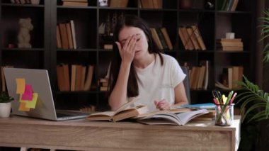 Güzel bir kütüphanedeki masada yorgun bir öğrenci. Okumaktan ve çalışmaktan başı ve gözleri ağrıyordu. Genç kadın elleriyle yüzünü tutuyor, kitapların arasında geçirdiği onca saatten sonra yorgun düşmüş..