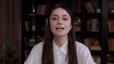 Web kamerasıyla konuşan genç bir esmerin portresi. Kadın, modern teknoloji ve internet bağlantısını kullanarak uzak video konferansına katılıyor. İş sonrası video arama etkinliği veya çalışma konsepti