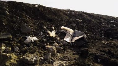 Toprak ve çöplerle dolu tepe izinsiz çöplüklerden rüzgar tarafından getirildi. Karton kutular, plastik şişeler, plastik torbalar, kauçuk. Doğa tahribatı kavramı, insanlar tarafından çevre kirliliği