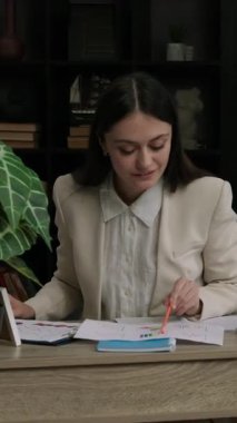 Neşeli ve neşeli bir ofis kadını bugün için belirlediği tüm görevleri yerine getirir. Çalışan kadın çeşitli dosya ve istatistikleri analiz eder. Modern ve rahat bir ofiste çalışma süreci