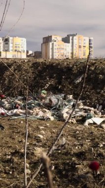 Şehre yakın, apartmanlara yakın ve doğaya atılmış çöp yığınlarına bakın. Geri dönüşümsüz çöp ile çevre kirliliği. Geri dönüşümsüz plastik ile çevresel yıkım