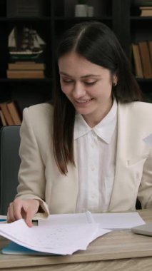 Neşeli kadın psikolog psikolojik değerlendirme raporunu analiz ediyor. Neşeli psikolog hastalarla bir sonraki seansa hazırlanmak için gözlemler yazıyor.