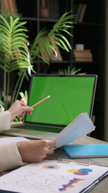 Omzunun üzerinden: Masasında oturan genç yaratıcı bir kadın ekran yönetimi, istatistik ve grafikleri gösteren bir masaüstü bilgisayarı kullanıyor. Profesyonellerin çalıştığı modern ofis.