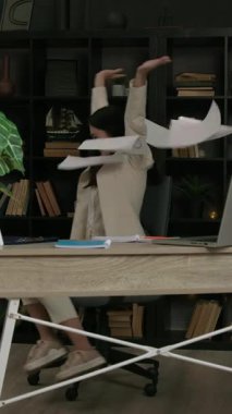 Genç iş kadını, şirketi geliştirme aşamasına getirmeyi başardığına dair kağıtları mutlulukla fırlatıyor. Karmaşık görevi başardığı için mutlu bir işveren.