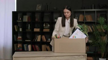 Kızgın genç kadın, önceki işinden kalan kişisel eşyalarla dolu karton kutuyu eline alıyor ve hayal kırıklığına uğruyor. Klasik takım elbiseli bir kadın öfke dolu işini değiştiriyor.