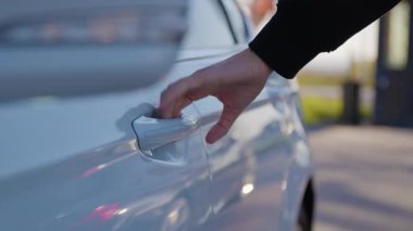 Arabasını uzaktan kontrol etmek için akıllı telefon uygulaması kullanan bir adamın eli. Adam arabayı anahtarsız giriş sistemi olan bir akıllı telefonla açıyor. Anahtarsız aracın kilidini aç.