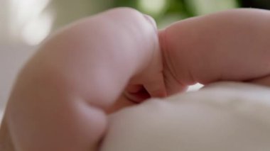 Mutlu bir bebek ağzının yakın plan görüntüsü. Yeni doğmuş bir bebeğin geniş gülümsemesi ellerini ağzına sokuyor. Mutlu bebek ağzı açık gülüyor, aktif ve elleriyle oynuyor..