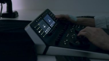 RGB tekerleklerini kullanarak ayarlar ve değişiklikler yapan bir erkek renk uzmanının elleri. Bir renk panelinin yakın plan görüntüsü. Yapım sonrası video. Renk derecelendirme ve düzenleme için profesyonel ekipman