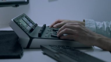 RGB tekerleklerini kullanarak ayarlar ve değişiklikler yapan bir erkek renk uzmanının elleri. Bir renk panelinin yakın plan görüntüsü. Yapım sonrası video. Renk derecelendirme ve düzenleme için profesyonel ekipman