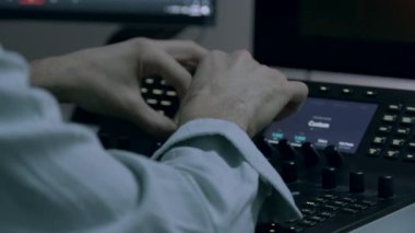Bir renk panelinin yakın plan görüntüsü. Bir erkek renk uzmanının elleri ve ekranlar RGB tekerleklerini kullanarak ayarlamalar ve değişiklikler yapıyor. Yapım sonrası video. Profesyonel programlar ve aygıtlar