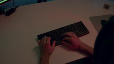 Birkaç şirketin veri platformlarına sızan isimsiz bir hackerın ellerinin yakın plan görüntüsü. Klavyede hızlı bir şekilde yazan isimsiz biri. Hacker saldırısı, siber güvenlik.