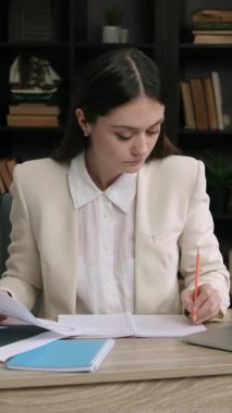 Ofis masasında oturan klasik takım elbiseli bir iş kadını. Yönetici çeşitli şirket istatistiklerini ve grafiklerini analiz ediyor ve birkaç büyüme stratejisi oluşturmayı düşünüyor. İş geliştirme şirketi.