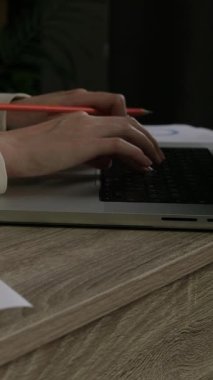 İş verilerini ve rakamları internete aktaran bir bilgisayarın üzerine yazı yazan bir kadının yakın plan görüntüsü. Muhasebeci, şirketlerin belge, diyagram, şema, veri ve mali rakamlarını kontrol ediyor.
