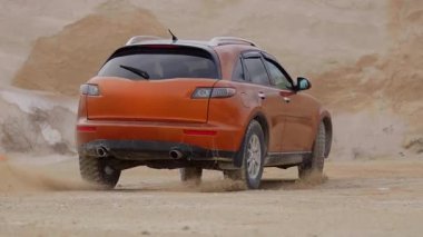 Spor araba kumda sürükleniyor. Adrenalinle dolu turuncu bir arabayla kum ocağında sürükleniyor. Kontrol ve güvenlik güçlü araba kum üzerinde 4 tekerden çekişle sürüklenir. Sürüklenme yarışmaları. Araba yarışları