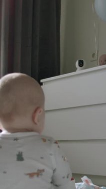 Halıda oturan bir bebeğin arka planda oturması, güzel dekore edilmiş odasında oyuncaklarla oynaması. Meraklı bebek sabahları tek başına sessizce oynuyor.