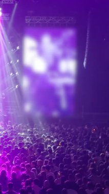 Sanatçılar uluslararası bir konferansta büyük bir seyirci kitlesiyle performans sergiliyorlar. Karanlık konferans odasında heyecanlı iş seyircileri alkışlıyor. İş Teknolojisi Zirvesi. Işıklar