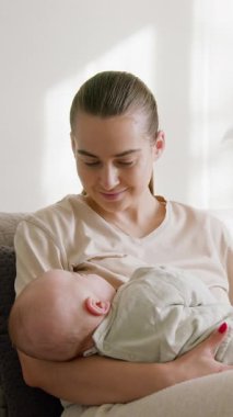 Mutlu anne bebeğini kollarına alıp onu beslerken gülümsüyor. Genç bir kadın evdeki ilahi sabah ışığında bebeğini emzirme işleminden zevk alıyor. Annelik ilahi süreci