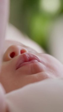 Çocukça bir bakış açısı. Bebek tombul elini ağzına sokuyor. Yeni doğmuş bir bebeğe bakma kavramı. Mutlu annelik kavramı. Ebeveynlerin küçük çocuklara sunduğu masumiyet ve güvenlik