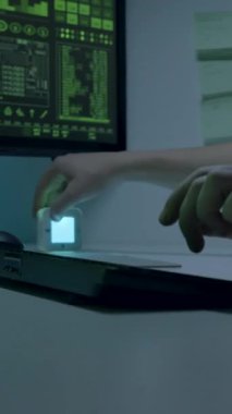 Ofis masasında, büyük monitörlerin önünde, kulaklığı başında duran erkek bir bilişim uzmanı, hızlı bir şekilde, çalışma saatlerini ayarlıyor. Programcı yazma kodları oluşturmak için yapay zeka kullanır.