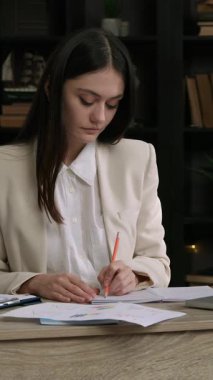 İş kadını iş yerinde boyun ağrısı çekerek iş yapıyor. Genç bir kadın elleriyle masaj yaparak kaslardaki gerginliği atmaya çalışıyor.