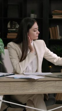 Takım elbiseli bir iş kadını, çalışma masasında çizelgeleri olan kağıtları alır. Meşgul genç bayan girişimci iş görüşmesi için belgeler hazırlıyor.