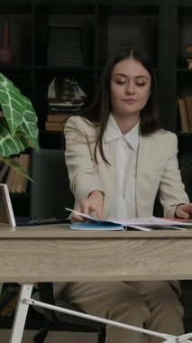 Mutlu kadın ofis çalışanı ofisteki sandalyeye kağıtları fırlatıyor. Takım elbiseli neşeli bayan çalışan başarılı iş anlaşmasını kutluyor