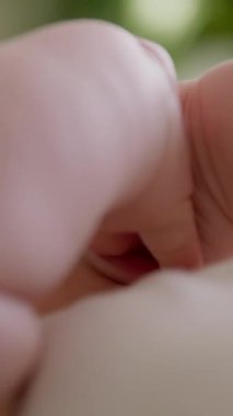 Mutlu bir bebek ağzının yakın plan görüntüsü. Yeni doğmuş bir bebeğin geniş gülümsemesi ellerini ağzına sokuyor. Mutlu bebek ağzı açık gülüyor, aktif ve elleriyle oynuyor..