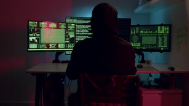 Birden fazla monitörün önündeki bilinmeyen hacker uykuya dalıyor ve hassas kişisel bilgilere ulaşıyor. Siber suçlar, siber güvenlik, hackleme, virüs, tehdit, internet ve kişisel verilerin çevrimiçi korunması