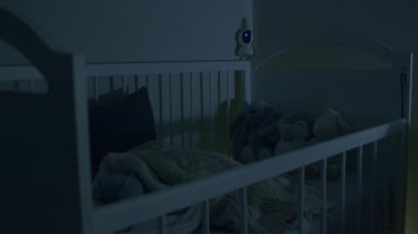 Güzel ve modern beşik ve bebek geceleri karyolada huzur içinde uyur. Bebeği izleyen bebek beşiğinden sarkan güvenlik kamerası. Wi-Fi üzerinden dijital aygıt. Güvenlik ve güvenlik.