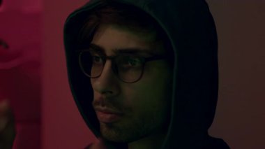 Gözlüklü genç hacker kafasına başlık geçirip yabancı hesapları ve sistemleri yasadışı yollarla hackliyor. Komutadaki tehlikeli bilgisayar korsanı sistemlere siber virüs bulaştırıyor.