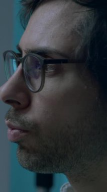 Gece geç saatte gözlüklü bir adam dizüstü bilgisayarın önünde kayıyor. Karanlıkta dizüstü bilgisayar kullanan kodlayıcı, programcı veya geliştirici. Bilgisayar ekranı yansıması olan gözlüğü kapat.